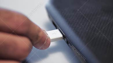 Close-up of connecting USB charging to laptop. Media. Connect charging with USB connector to electronic device. Power
