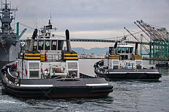 Two tugboats, Delta Billie and Delta Teresa leave the dock to guide a container ship to its berth in the Port of Los Angeles.