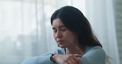 Close up portrait of young upset woman deep breathing and hiding face in hands, slow motion