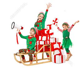Funny Christmas Kids with Megaphone preparing New Year Gifts. Santa Claus Helpers, Cute Little Elves on Sleigh packing Christmas