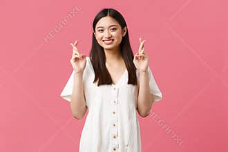 Beauty, people emotions and summer leisure concept. Optimistic asian girl having faith in dreams come true, cross