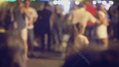 Many couples are dancing social dances in the street and there is little funny girl on foreground trying to compete
