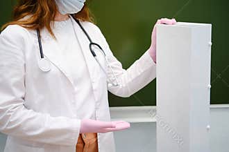 School nurse showing an ultraviolet lamp in a casing for air disinfection in a classroom. The problem with lessons in the