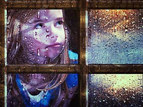 Girl at window in rain