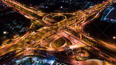 Time-lapse of car traffic transport on multiple lane highway or winding road expressway in Asia city at night, drone aerial view