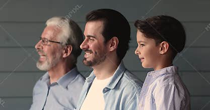 Smiling three multigenerational male family looking in distance.