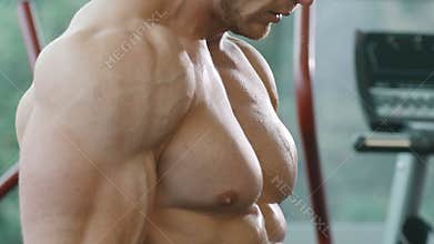 Athletic man training pumping up biceps muscles