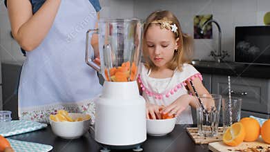 Little Girl Helping Mother to Cook Smoothie