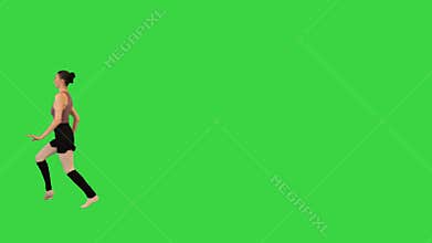 Young ballerina training a jump on a Green Screen, Chroma Key.