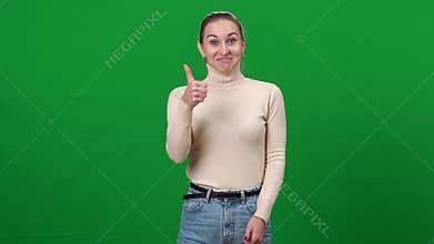Satisfied excited happy smiling woman showing thumb up shaking head yes looking at camera at chromakey green screen