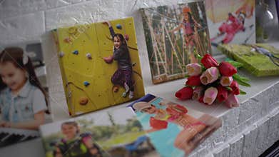 photo canvases of active little girl and flowers tulips as a holiday gift lie on the shelf