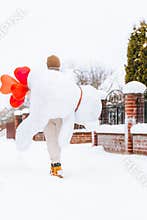 Young man from behind hugs holding big teddy bear soft toy gift heart air balloons on this special day surprising girlfriend. roma