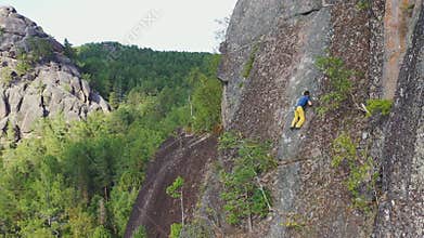 Free solo climbing on a rock wall in the Siberian nature Reserve Stolby.
