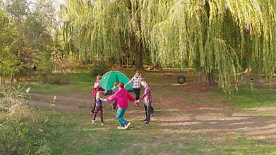 Pull away aerial shot group of people dance and rest in park. Group of people have active camp rest together