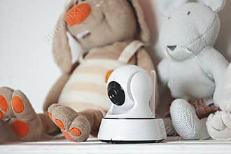IP camera on the shelf with toys, serving as baby monitor