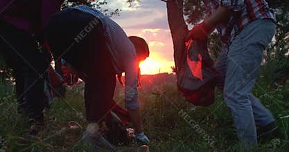 Low view of young volunteers collecting plastic on the environment