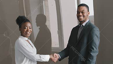 Happy African American female hr bank manager insurer handshake job applicant get hired at interview. Boss wearing suit