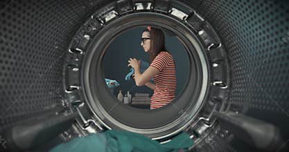 Bored housewife loading the washing machine