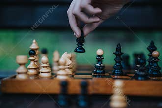 Strategic chess move on a wooden chessboard in outdoor setting