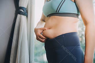 fat woman, fat belly, chubby, obese woman hand holding excessive belly fat with measure tape, woman diet lifestyle concept
