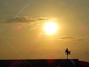 Silhouetted jogger exercising  at dawn in beautiful sunrise , Bali, Indonesia.