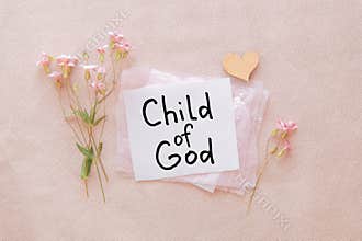 I am a child of God - christian text on card with little flowers on light pink background, biblical verse and religion concept