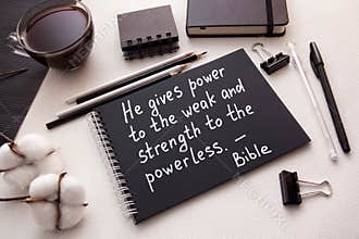Christian biblical lettering - He gives power to the weak - text on paper on the table with black and white stationery