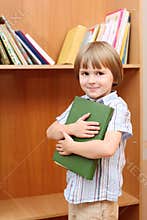 Boy with book against shelf