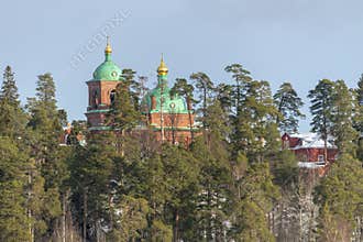 View of the Voskresenskiy Skete of Valaam Monastery in winter from the forest