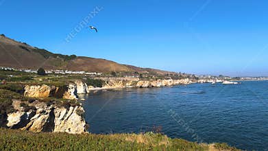 Scenic coastal landscape featuring seaside residences and rugged cliffs.