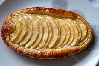 French fresh baked sweet puff pastry with fresh apple fruits in sirup in confectionery shop