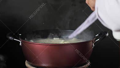 Boiling cassava in hot pot on stove
