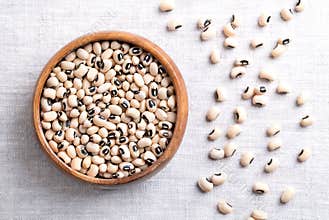 Dried black eyed peas in a wooden bowl over linen