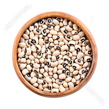 Dried black eyed peas, California blackeye beans in wooden bowl