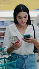 Vertical Video. Pretty Lady On A Calorie Conscious Diet Analyzes Can Contents And Noting Nutritional Information Into