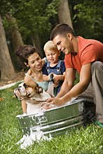 Family giving dog a bath.