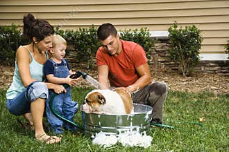Family giving dog a bath.