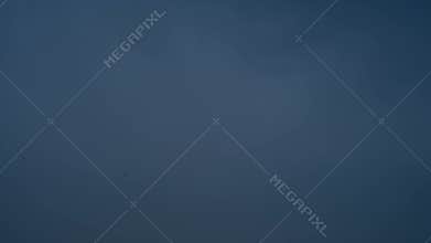 Birds flying high in dark cloudy sky and thunderbolt