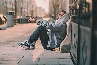 man in hoodie on a street sad