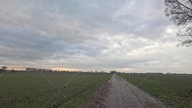 Car ride to the horizon between fields and meadows and clouds