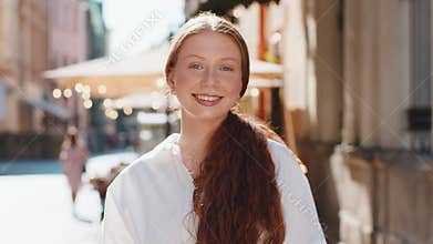 Teenager girl use smartphone typing text messages browsing internet finishing work looking at camera