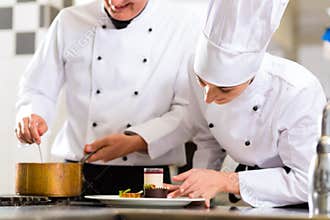 Chef team in restaurant kitchen with dessert