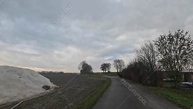 Car ride to the horizon between fields and meadows and clouds