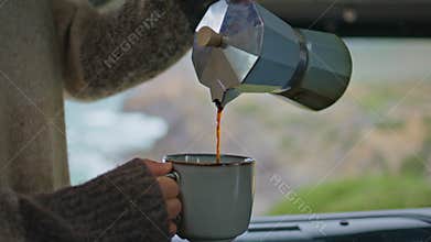 Woman hands pouring espresso in cup enjoying morning at motorhome close up.