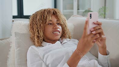 Woman holding cell phone on couch
