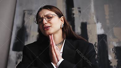 Young sad female having a video call using a laptop sitting on sofa at home. Emotional woman cries during an online call