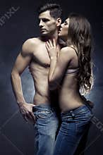 Beautiful young couple in love embracing indoor