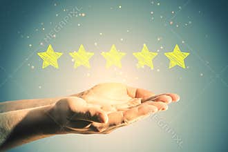 Close up of man hand holding 5 star rating on background. Customer service and excellent feedback concept