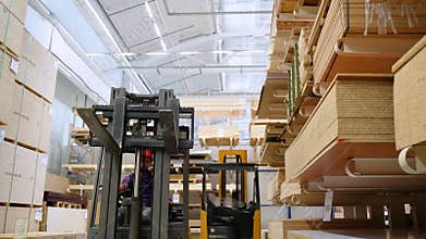 Forklift loader in storage lumber warehouse. Distribution products. Delivery. Logistics. Transportation