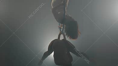 Two girls show tricks on a aerial hoop